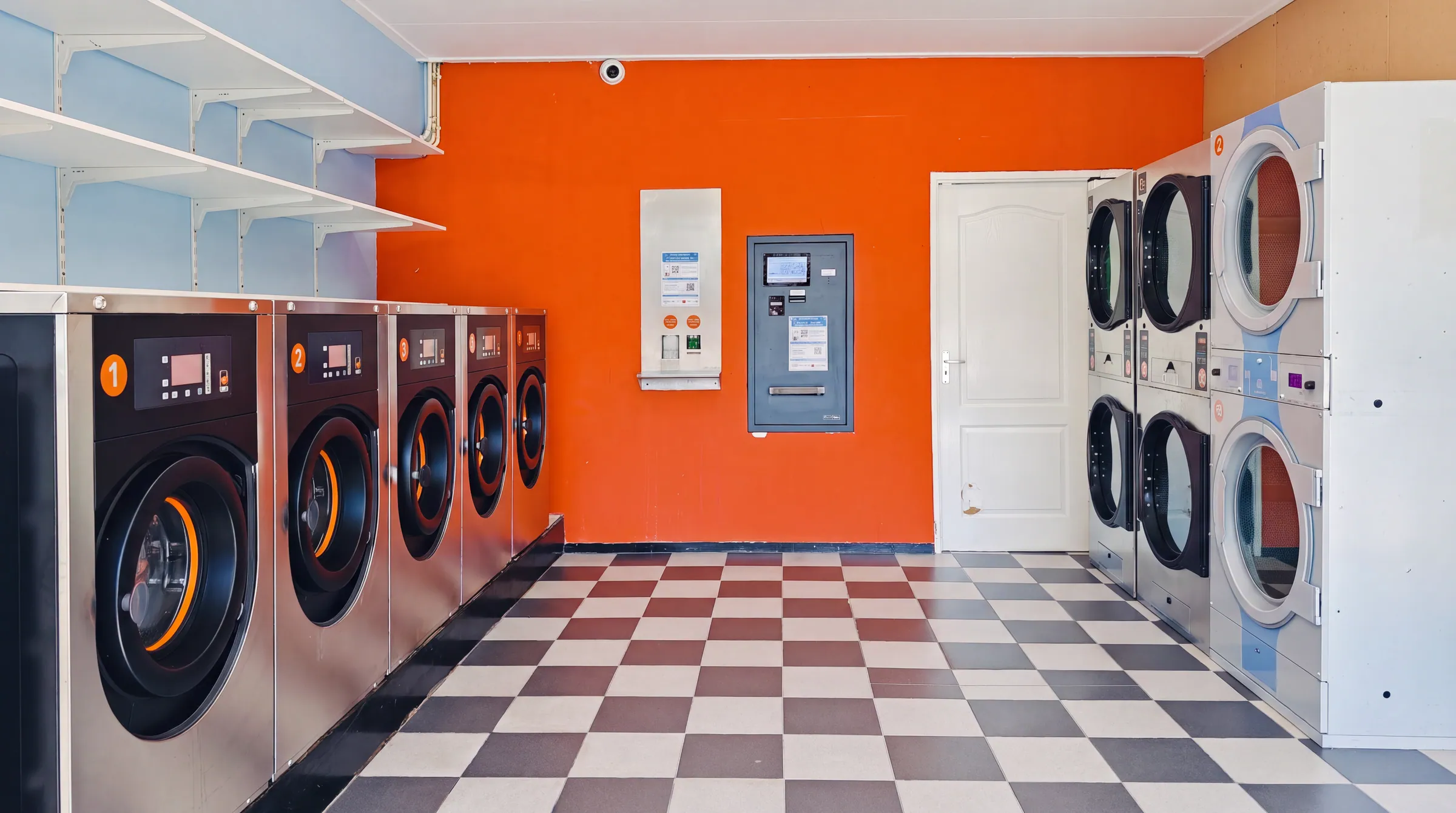 Wasmachines en drogers langs de oranje muur